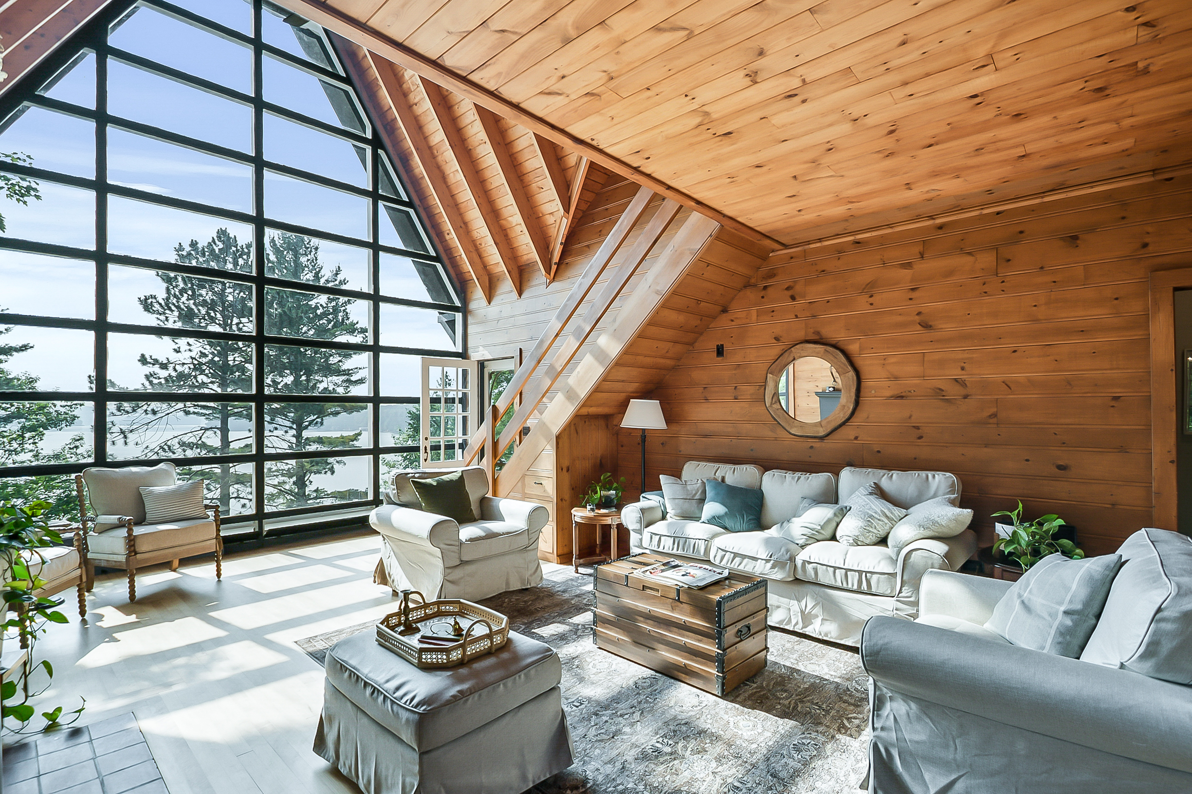 A cosy living room with soaring windows overlooking Peninsula Lake