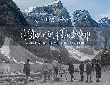 The bottom of the image is a black and white photo with a group of people in 1920's clothing and a camera on a tripod staring at Moraine Lake. The photo transitions upward to a 2018 photo of the same location in colour, the subtle changes to the landscape over a century are subtle but telling.